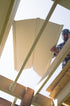 Person installing UnderDeck Shield panels on the topside of a deck.