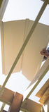 Person installing UnderDeck Shield panels on the topside of a deck.