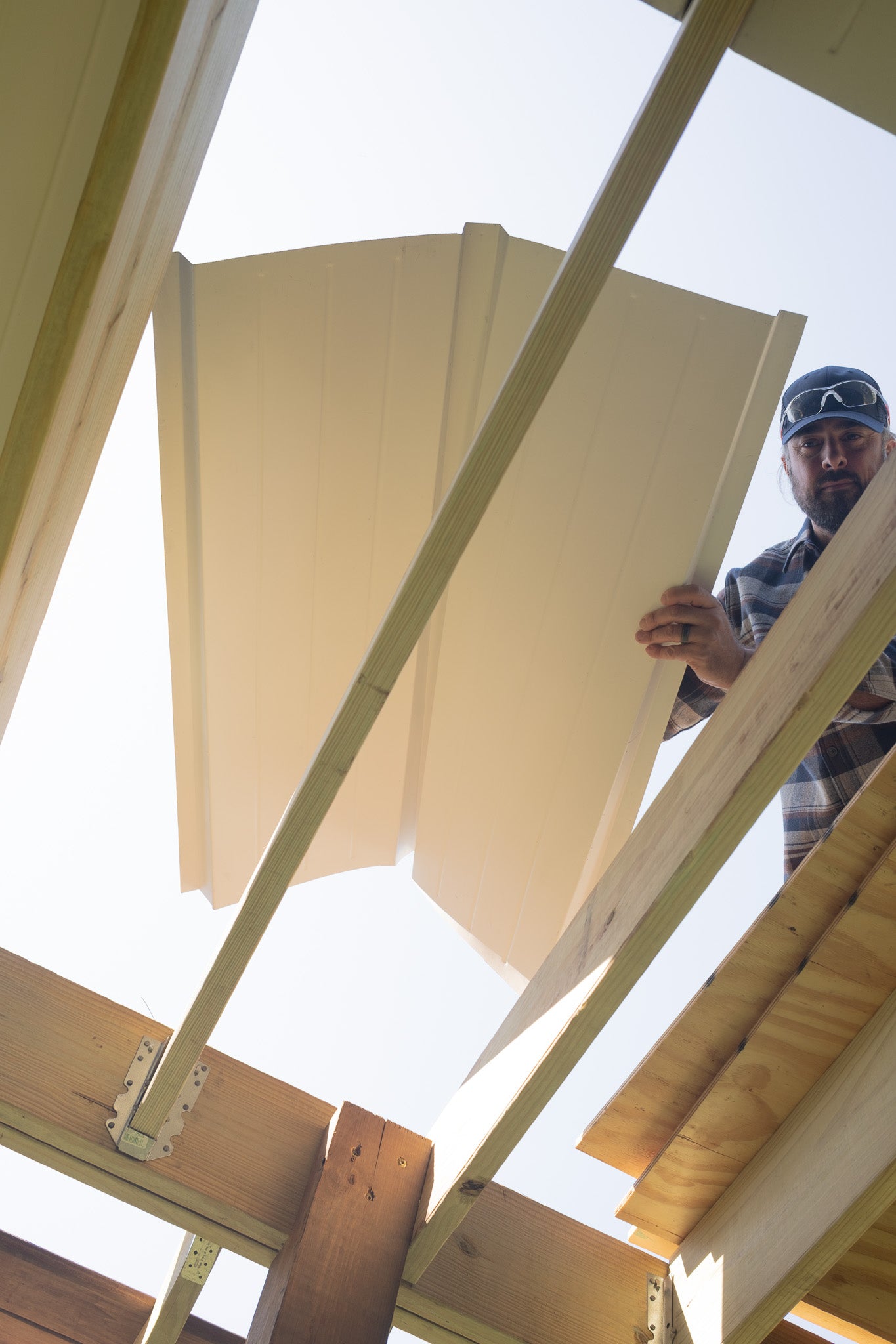 Person installing UnderDeck Shield panels on the topside of a deck.