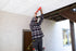 Person installing an UnderDeck Shields panel with caulk.